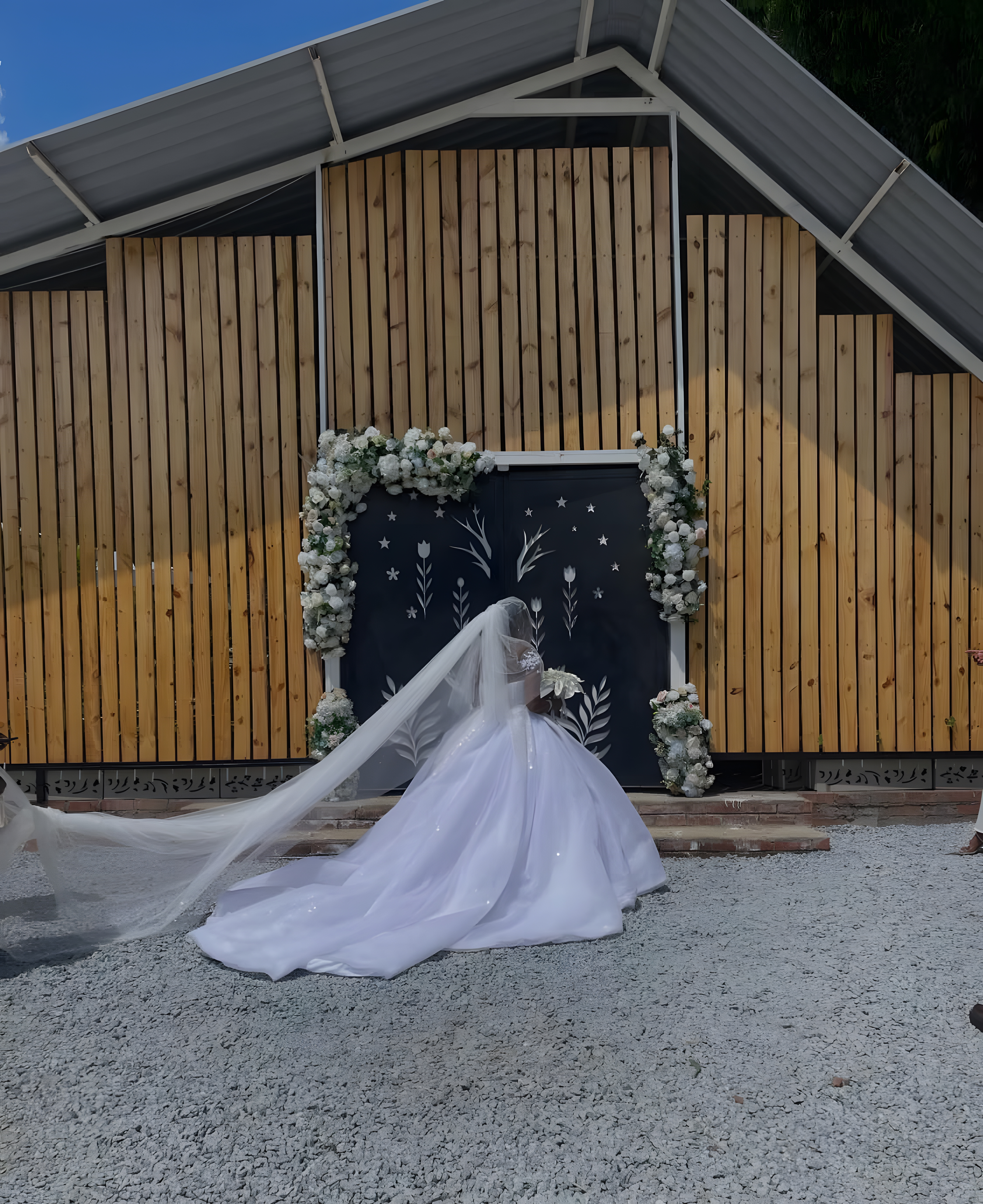 A luxury outdoor wedding reception with elegantly dressed guests celebrating as a bride and groom walk down the aisle