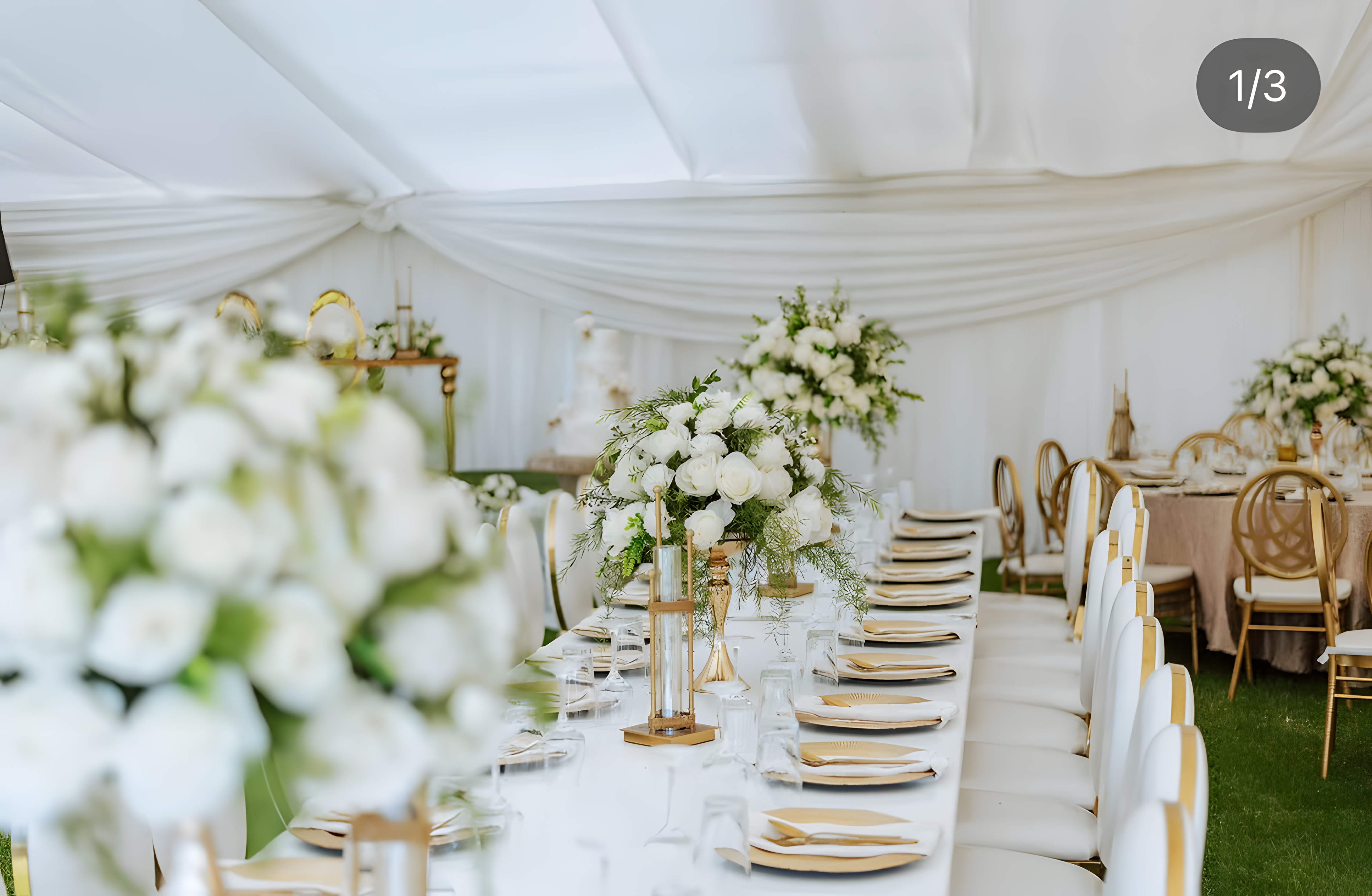 The Pavilion — floral arch and white chairs